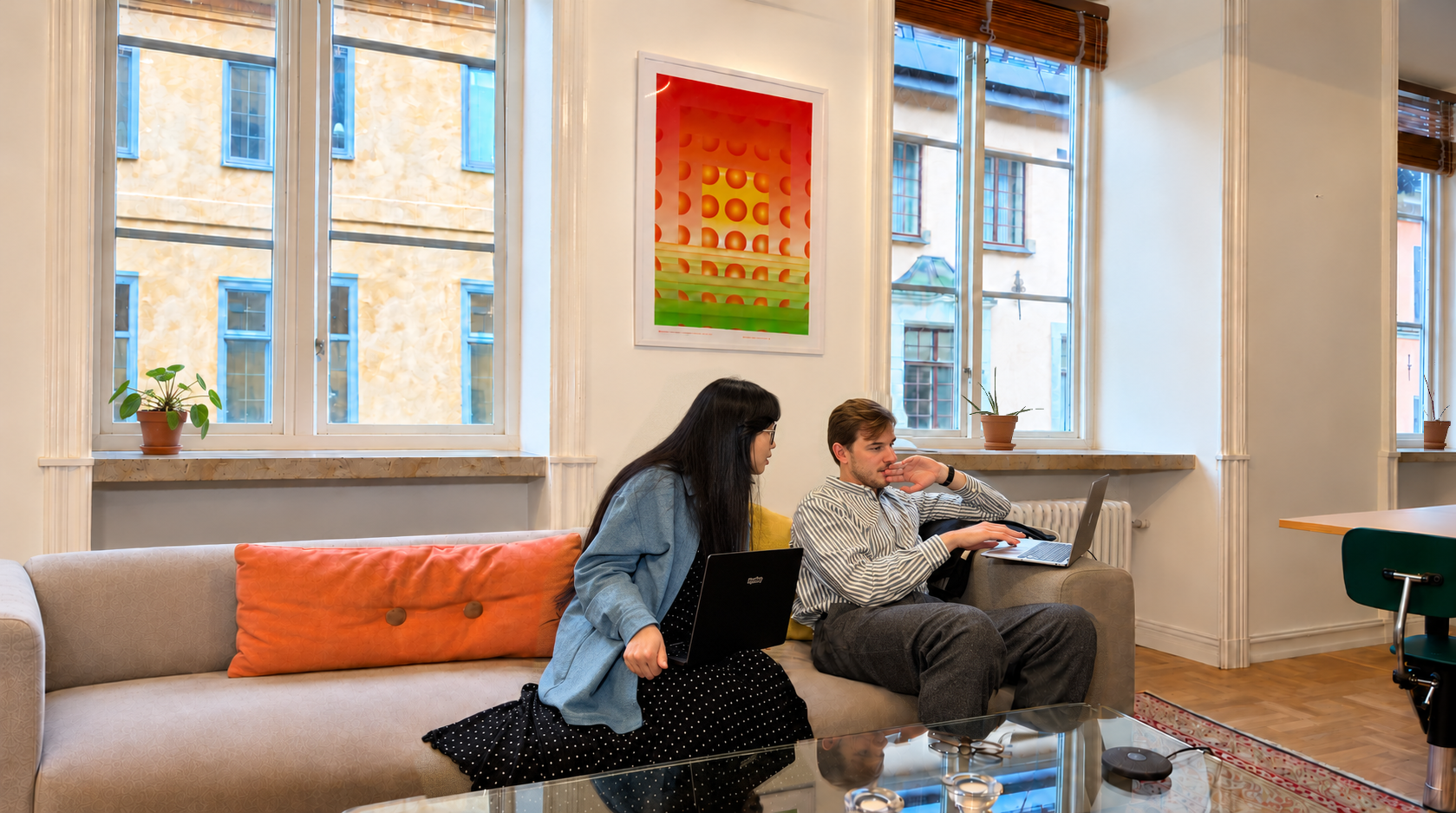 Two colleagues working together on a sofa in the Hybridity office
